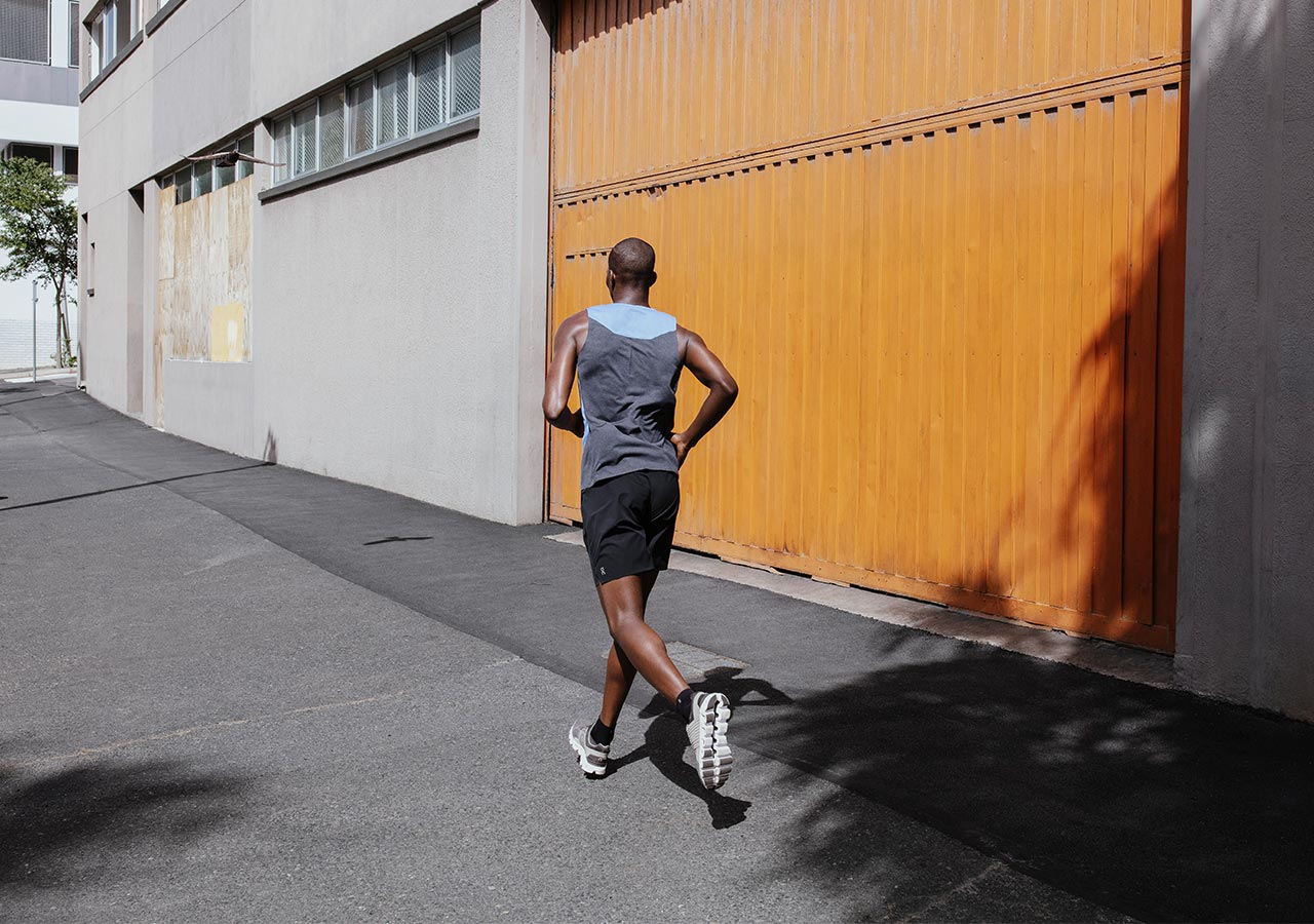 Mężczyzna biegnie w stroju sportowym i butach biegowych On running